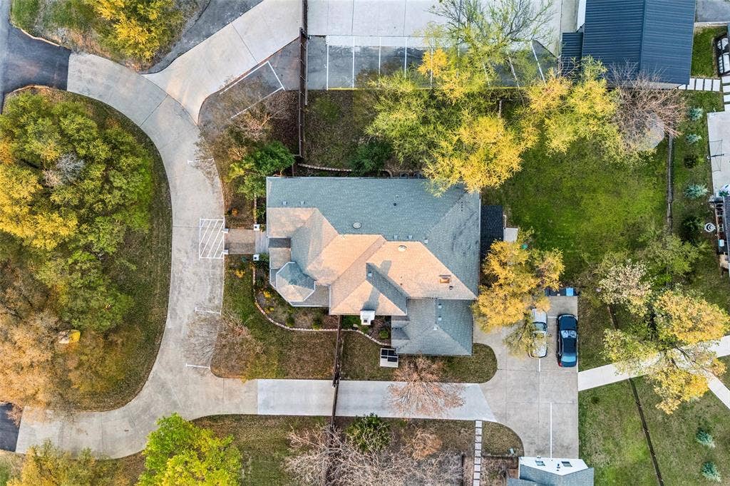 3706 Castle Drive, Rowlett, TX 75089 Expansive lot with mature trees, a multi-car driveway, and a well-defined paved access road