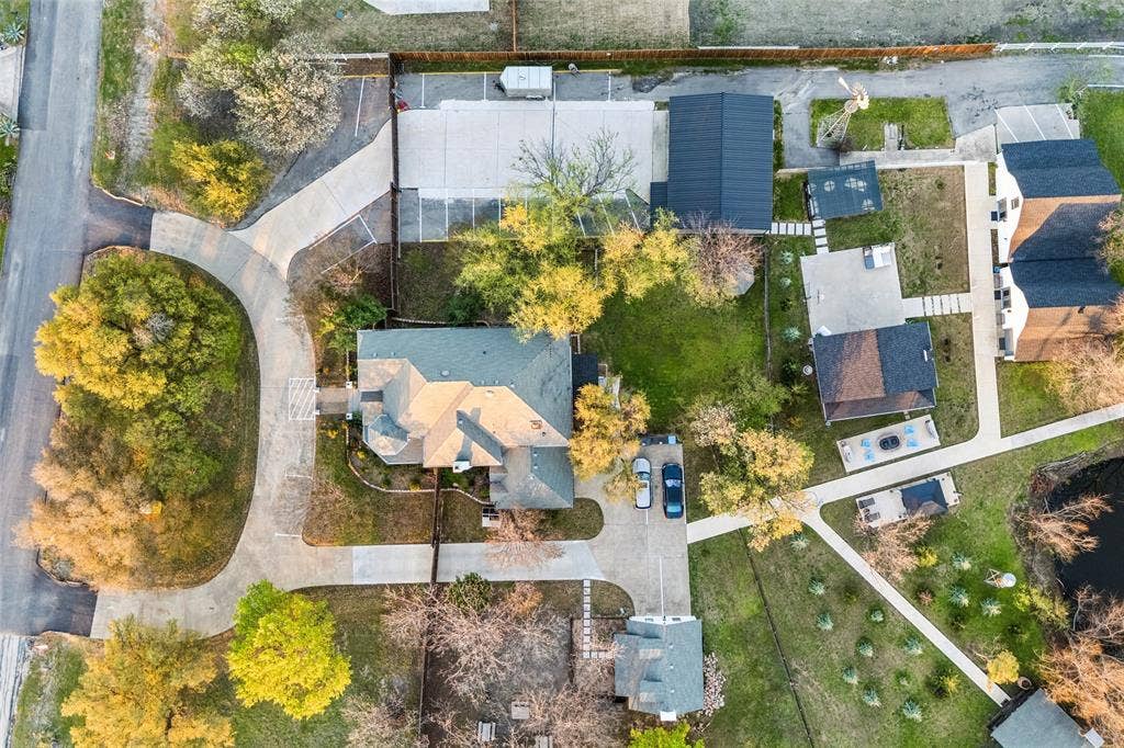 3706 Castle Drive, Rowlett, TX 75089 Expansive property with a curvilinear driveway, mature trees, and a detached building with a dark roof