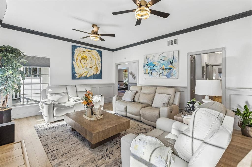 3706 Castle Drive, Rowlett, TX 75089 Spacious living area featuring wood-finish flooring, ceiling fans with integrated lighting, and crown molding