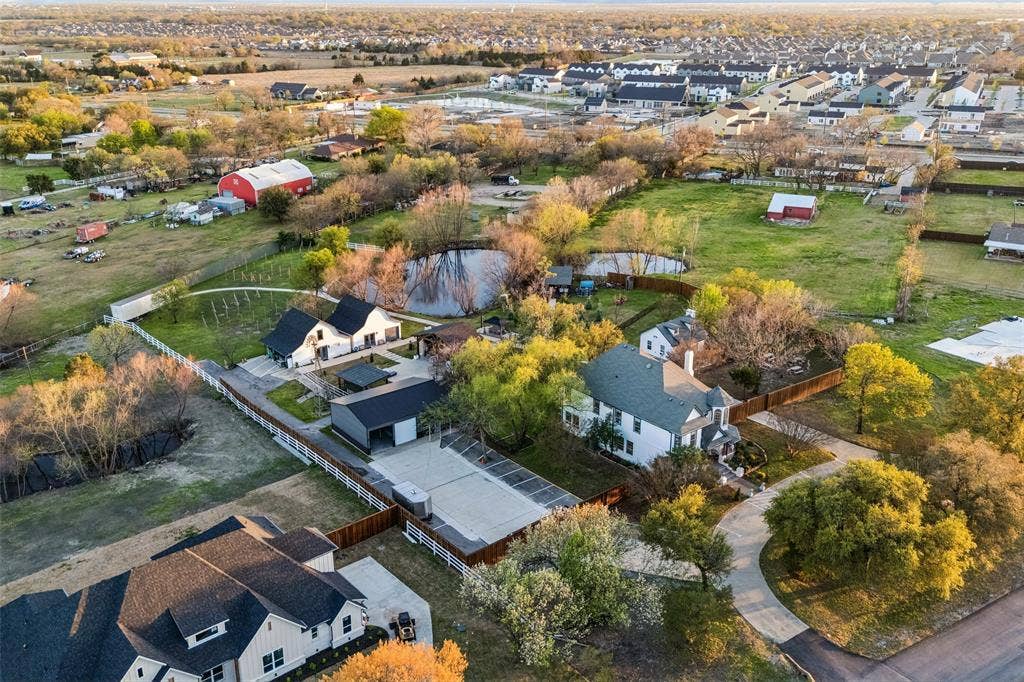 3706 Castle Drive, Rowlett, TX 75089 Expansive property featuring a pond, white picket fencing, and multiple outbuildings