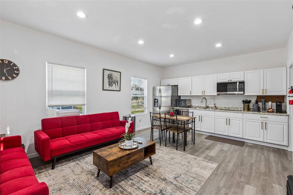 3706 Castle Drive, Rowlett, TX 75089 Open-concept living space featuring recessed lighting, light wood-finish flooring, white kitchen cabinetry with gold-tone hardware, and stainless steel appliances