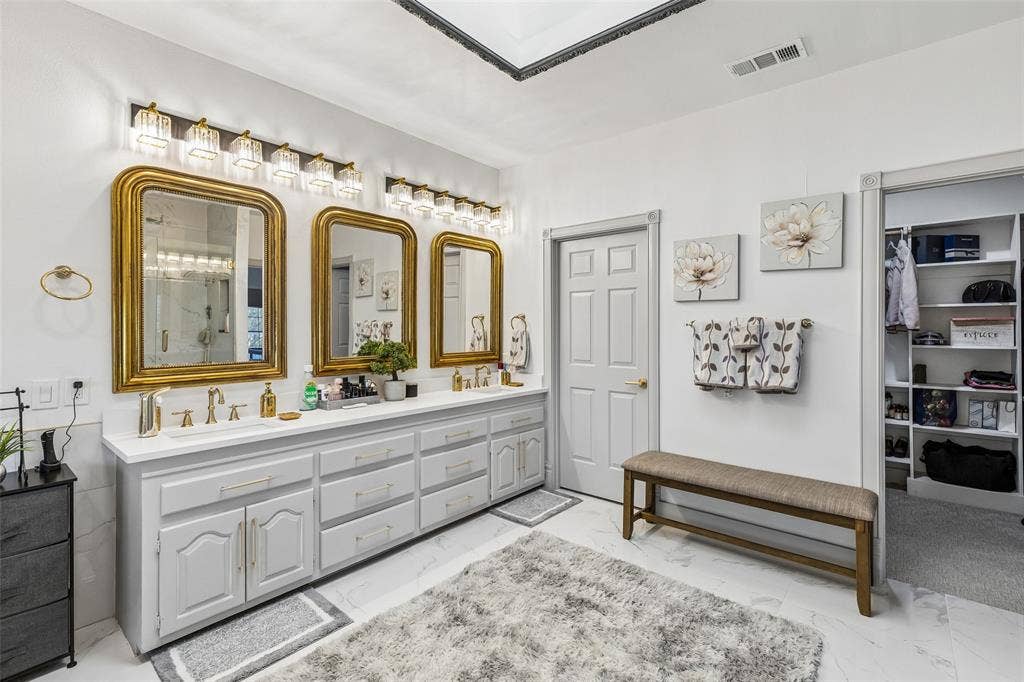 3706 Castle Drive, Rowlett, TX 75089 Dual vanity with light gray cabinetry, white countertops, and gold-framed mirrors