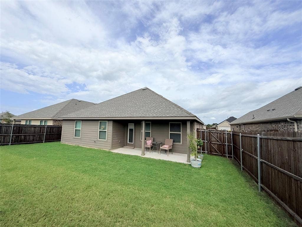 1602 Maple Ridge Drive, Princeton, TX 75407 Expansive backyard featuring a manicured lawn, full wood fencing, and a concrete patio