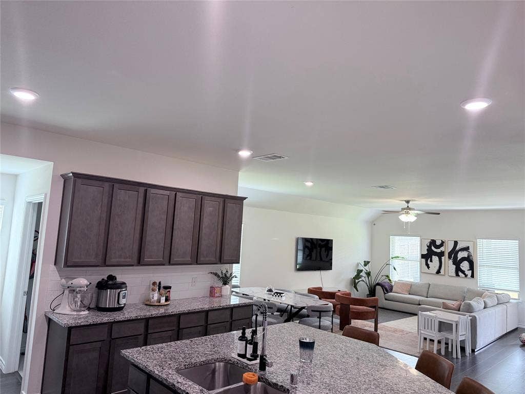 1602 Maple Ridge Drive, Princeton, TX 75407 Kitchen featuring wood-finish cabinetry, granite countertops, and a tile backsplash