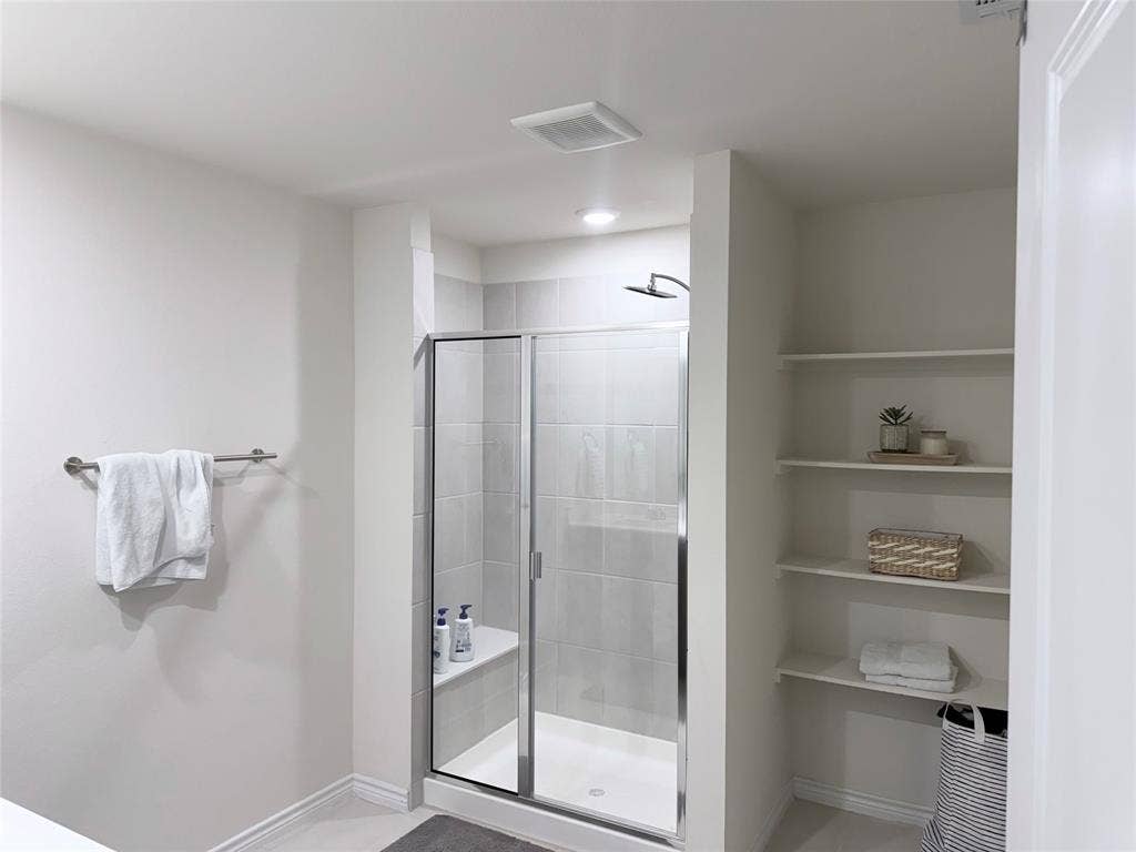 1602 Maple Ridge Drive, Princeton, TX 75407 Enclosed shower with a built-in bench, glass door, and tile surround