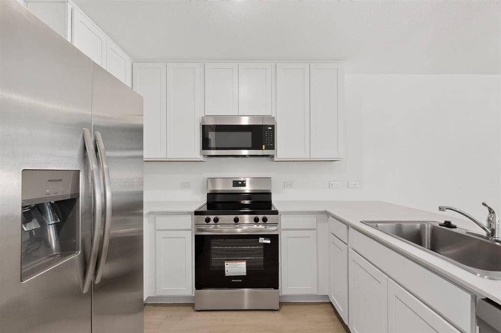 624 Kinglet Lane, Princeton, TX 75407 Stainless steel appliances, white cabinetry, integrated sink, and light-toned countertops