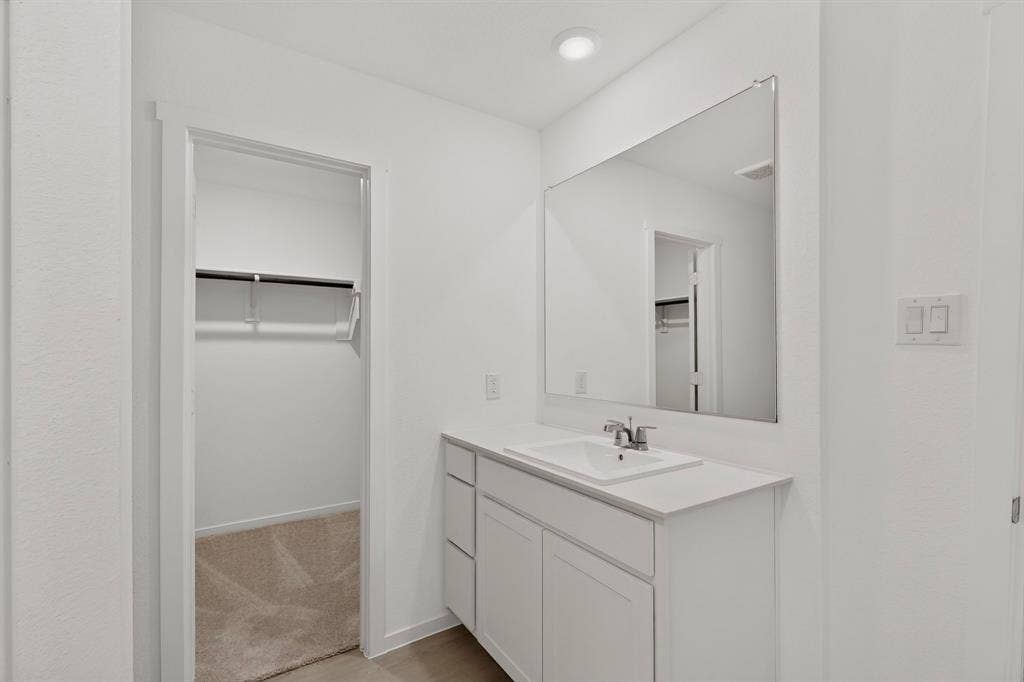 624 Kinglet Lane, Princeton, TX 75407 White vanity with an integrated rectangular sink, chrome faucet, and expansive wall-mounted mirror