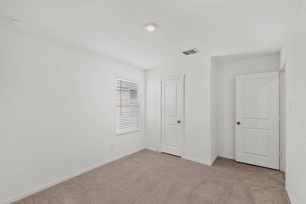624 Kinglet Lane, Princeton, TX 75407 Neutral tone wall finishes, recessed ceiling lighting, light-colored carpeting, white paneled doors, and a window with blinds