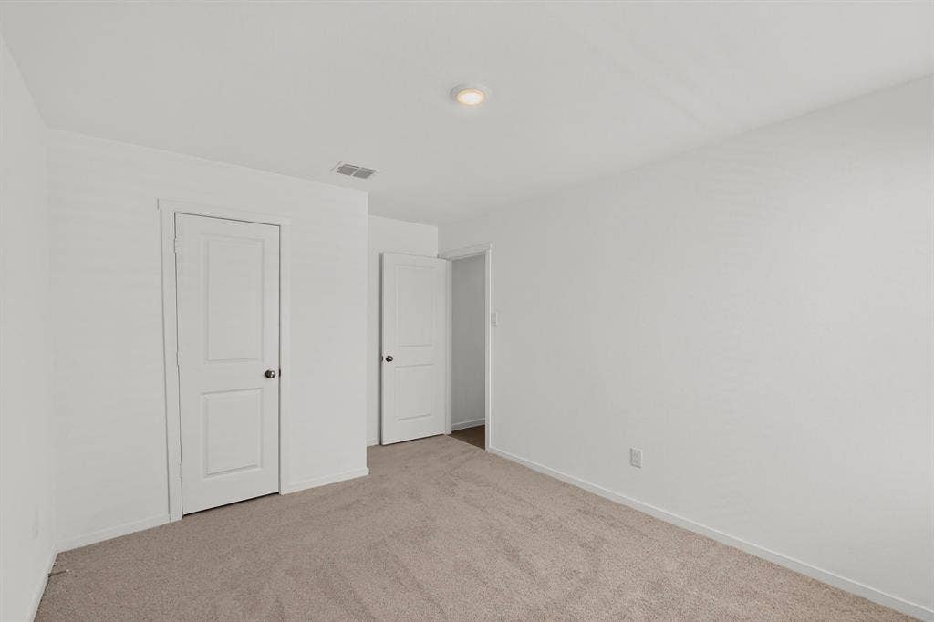 624 Kinglet Lane, Princeton, TX 75407 Neutral-toned carpeting, white walls, and white paneled doors