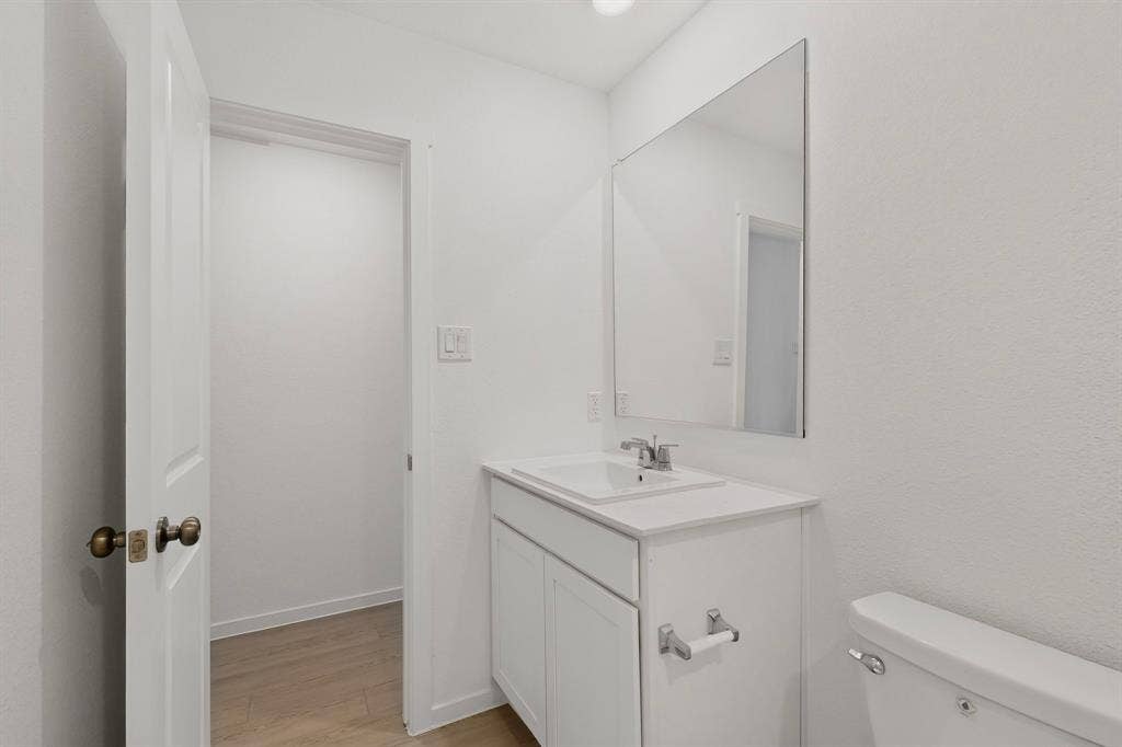 624 Kinglet Lane, Princeton, TX 75407 White vanity with integrated sink, chrome faucet, and a large wall-mounted mirror