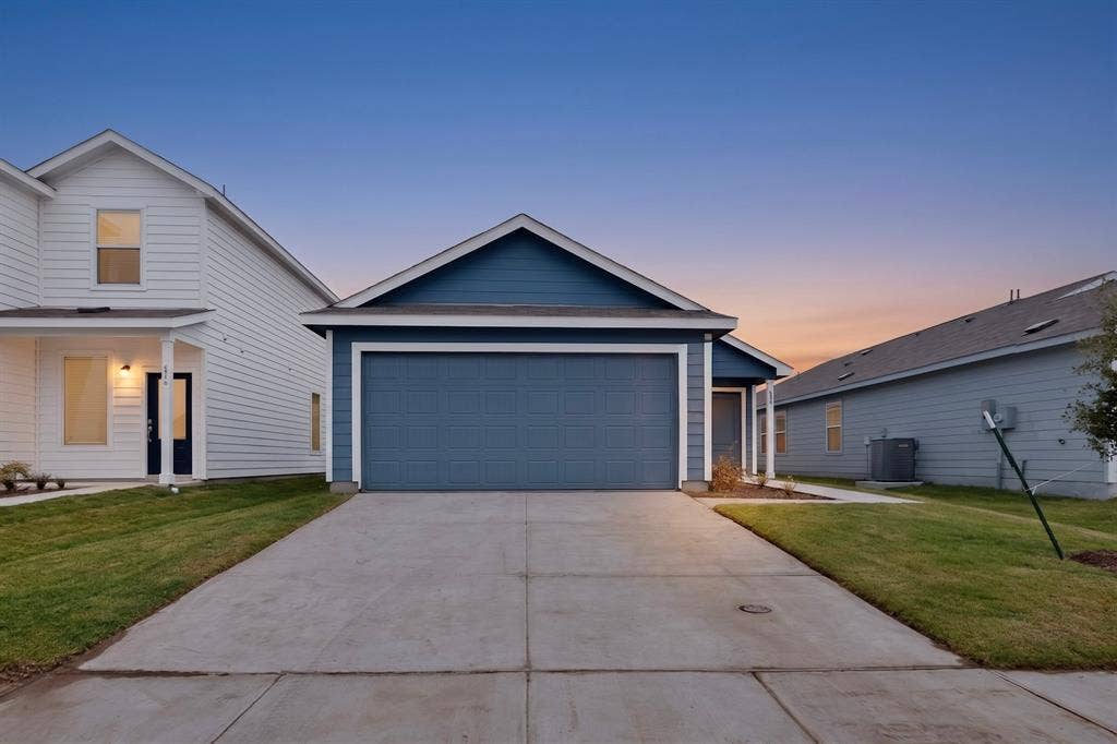 624 Kinglet Lane, Princeton, TX 75407 Siding exterior with a gable roofline, attached garage, concrete driveway, and manicured lawn