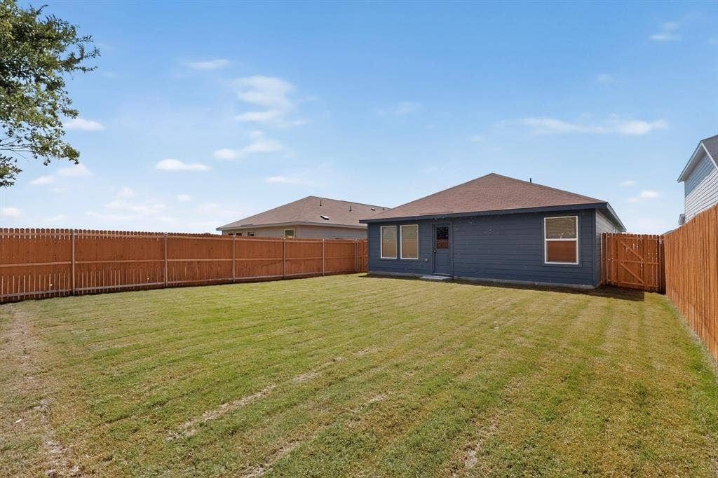 624 Kinglet Lane, Princeton, TX 75407 Fenced backyard with a blue exterior and a brown shingle roof