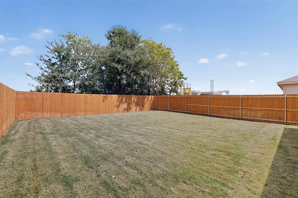 624 Kinglet Lane, Princeton, TX 75407 Expansive backyard featuring a manicured lawn and a privacy fence