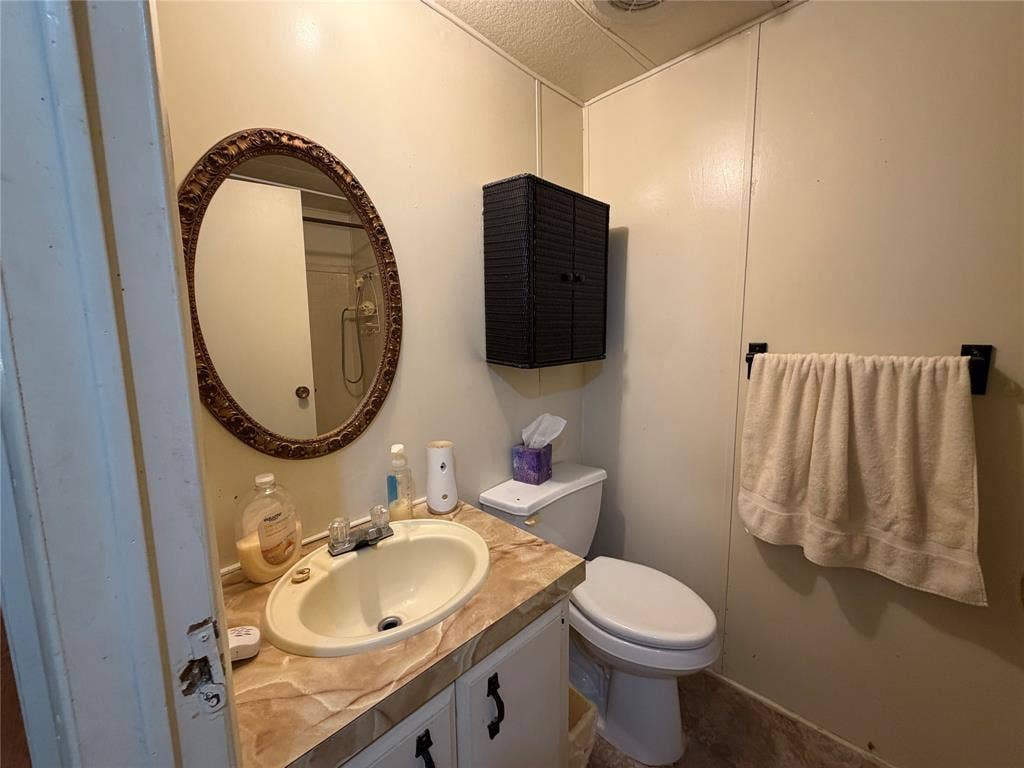 Vanity with integrated sink, wall-mounted mirror, and cabinet storage