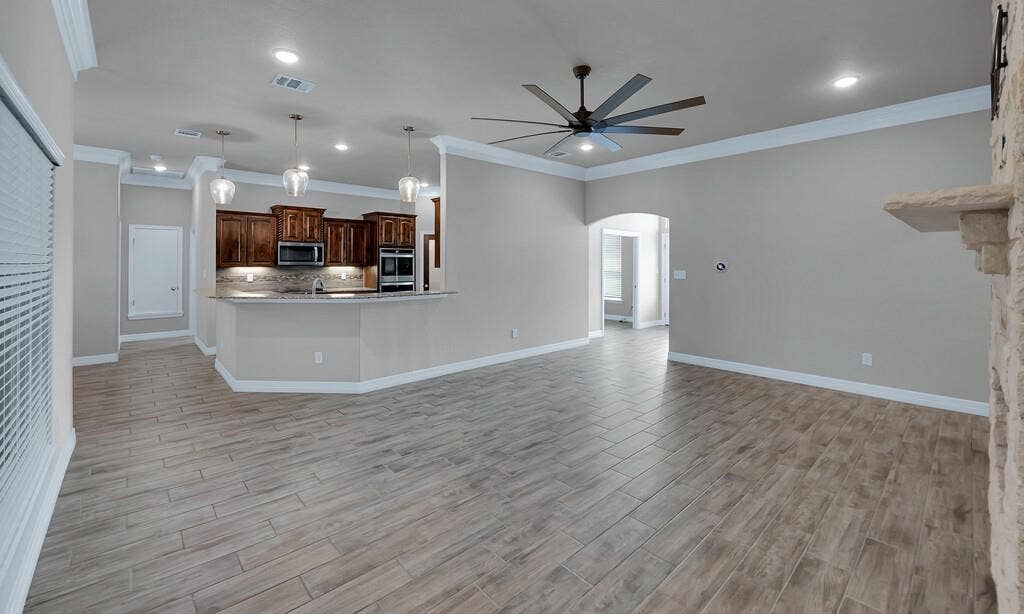 279 Sportsman Drive, Lorena, TX 76655 Open-concept living area with wood-look tile flooring, crown molding, and recessed lighting