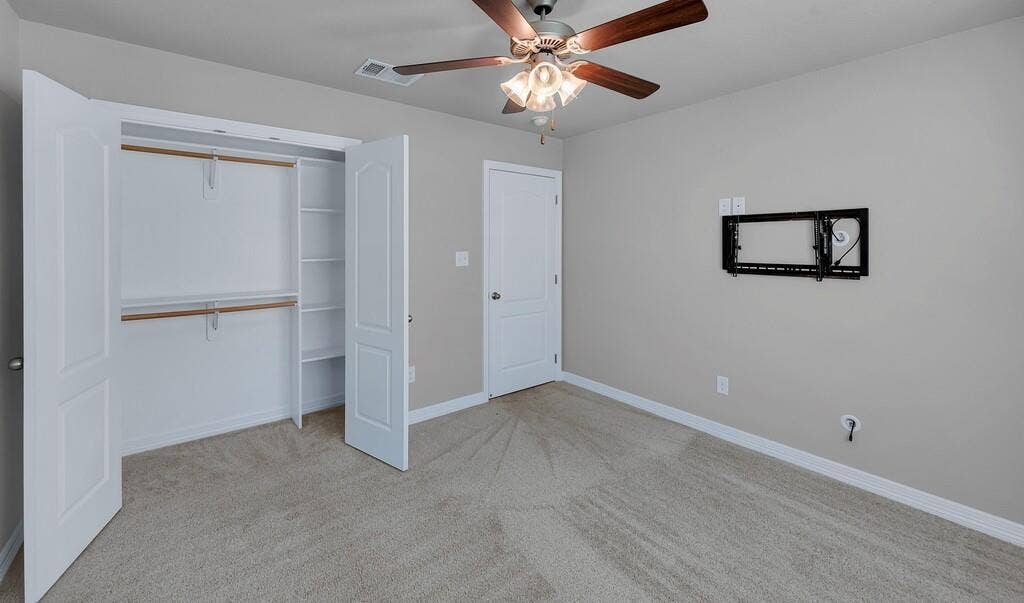 279 Sportsman Drive, Lorena, TX 76655 Spacious room featuring carpeted flooring, a ceiling fan with integrated lighting, and a closet with bi-fold doors and built-in shelving