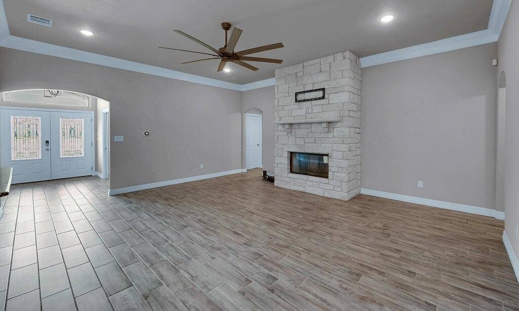 279 Sportsman Drive, Lorena, TX 76655 Stone fireplace with a mantle, wood-finish flooring, ceiling fan, recessed lighting, and crown molding