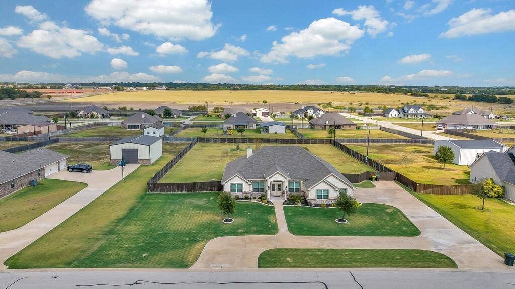 279 Sportsman Drive, Lorena, TX 76655 Expansive property featuring a spacious concrete driveway, established fencing, and a detached metal storage building