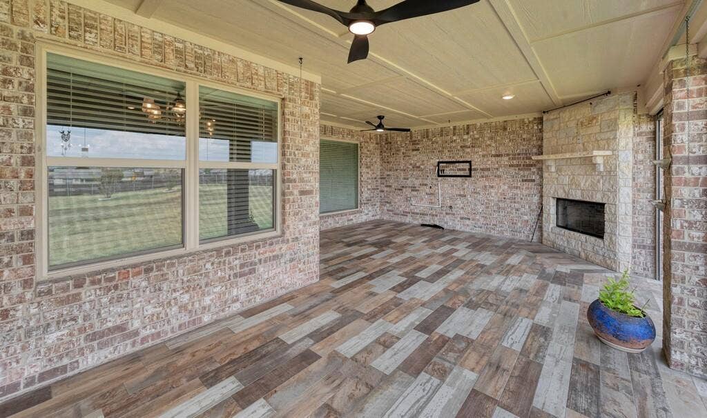 279 Sportsman Drive, Lorena, TX 76655 Spacious covered patio with wood-finish plank flooring, ceiling fan, and brick exterior walls, Remote Solar Screens
