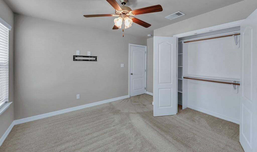 279 Sportsman Drive, Lorena, TX 76655 Plush carpeting, ceiling fan with integrated lighting, window with blinds, and a built-in closet with shelving and hanging rods