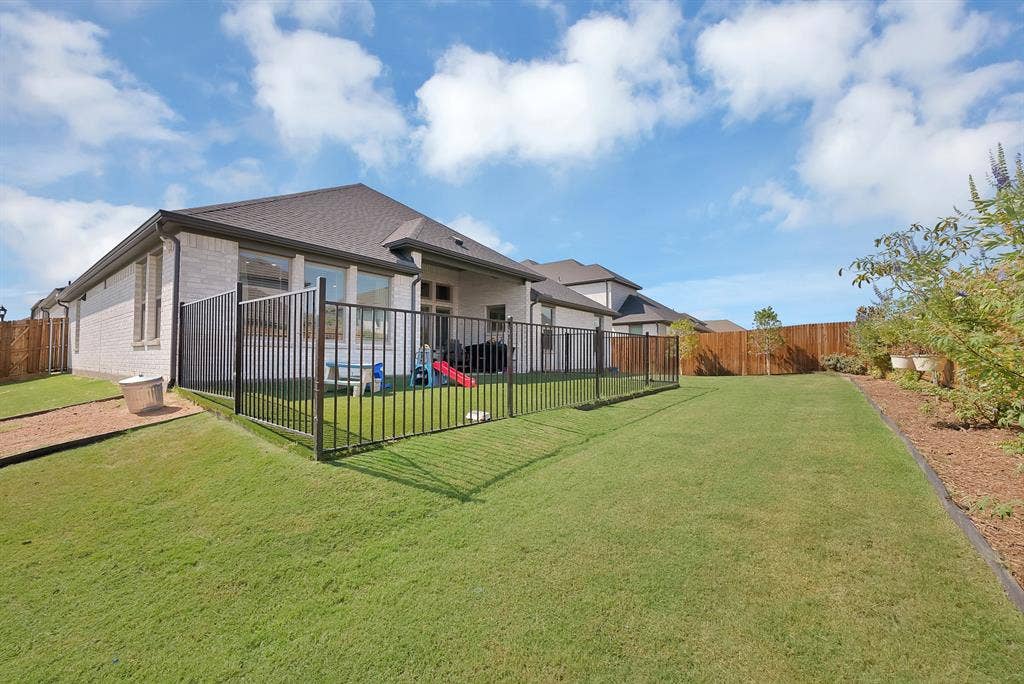 3701 Turpin Drive, Princeton, TX 75071 Another view of the backyard showcasing the wrought iron fenced in play area with artificial turf.
