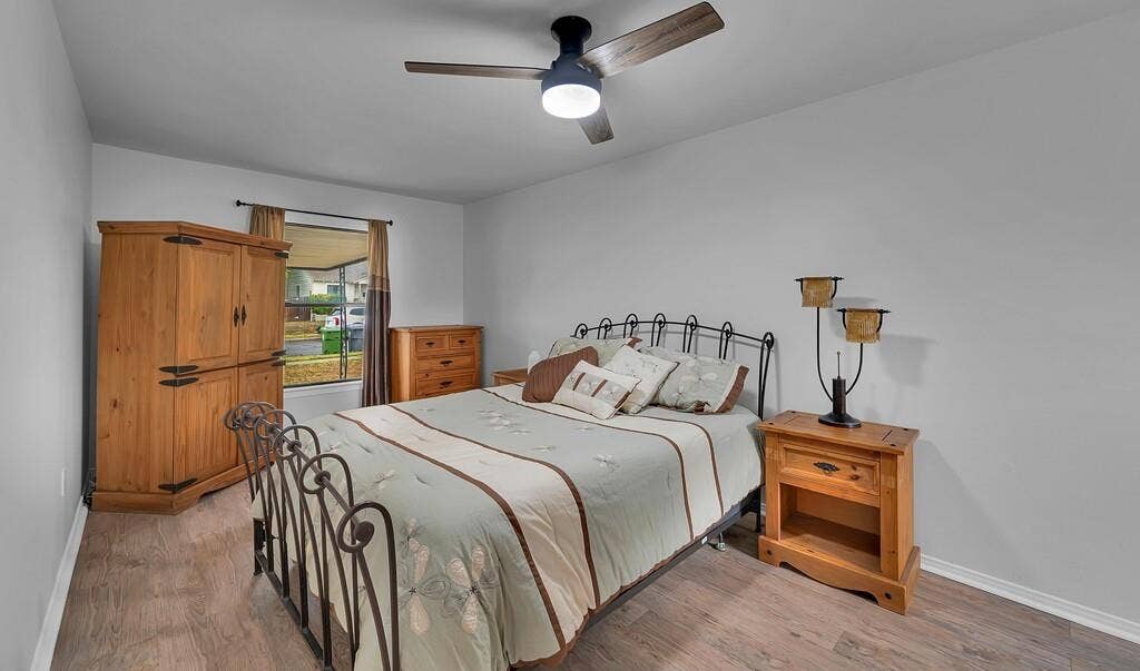 3720 Trice Avenue, Waco, TX 76707 Wood-finish flooring, a window with curtains, and a ceiling fan with integrated lighting