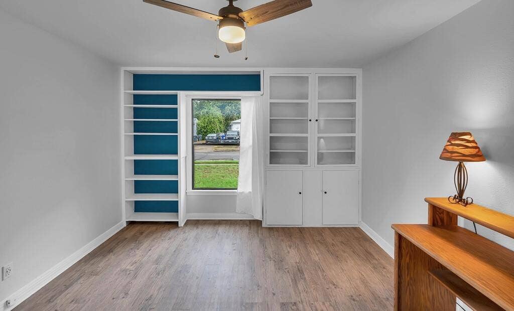 3720 Trice Avenue, Waco, TX 76707 Wood-finish flooring, built-in shelving, built-in cabinetry with glass inserts, and a ceiling fan with integrated lighting