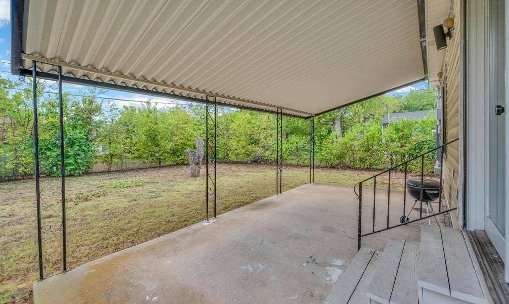 3720 Trice Avenue, Waco, TX 76707 Covered concrete patio with metal support posts, wood-finish steps, and a metal handrail