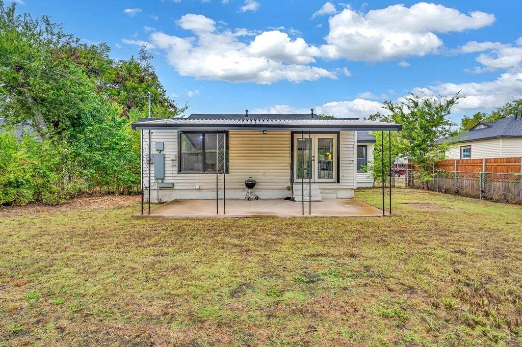 3720 Trice Avenue, Waco, TX 76707 Rear exterior with a concrete patio, covered by a black metal awning, featuring double glass doors and a large window