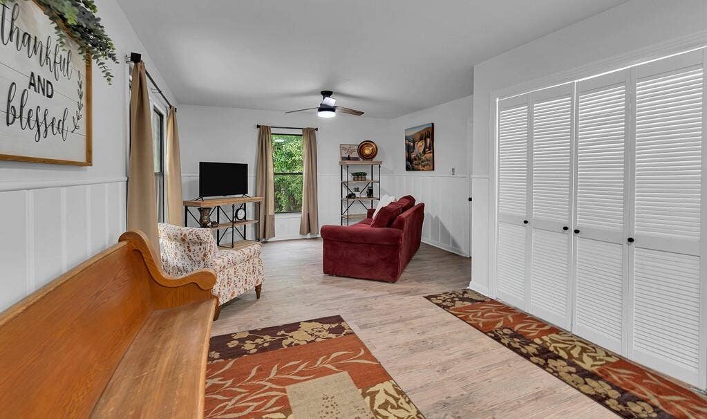 3720 Trice Avenue, Waco, TX 76707 Light wood-finish flooring, white board and batten wall paneling, and an overhead ceiling fan