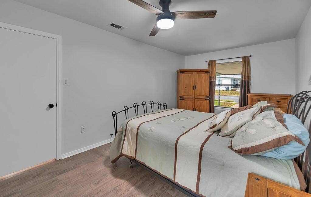 3720 Trice Avenue, Waco, TX 76707 Wood-finish flooring, ceiling fan with integrated lighting, window with exterior street visibility, and painted walls