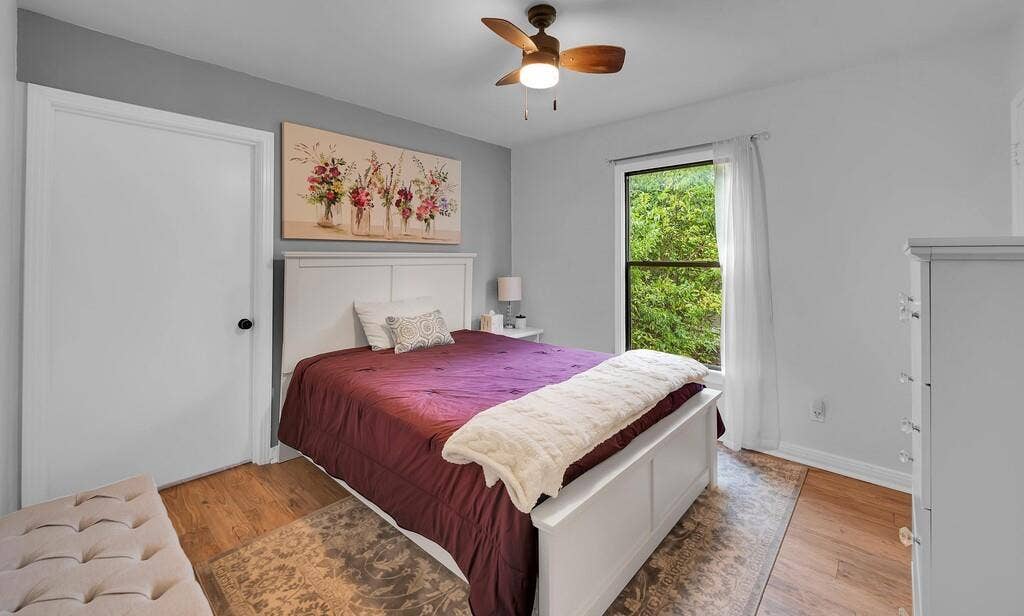 3720 Trice Avenue, Waco, TX 76707 Bright secondary bedroom with gray walls, wood-finish flooring, and natural light from a large window