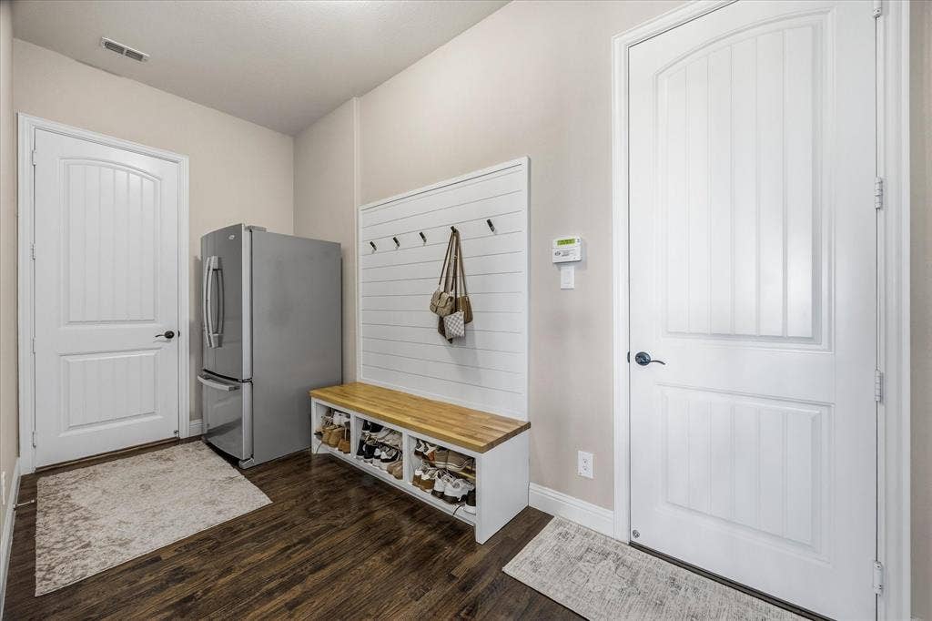 Wood-finish flooring, built-in storage bench, and white paneled doors
