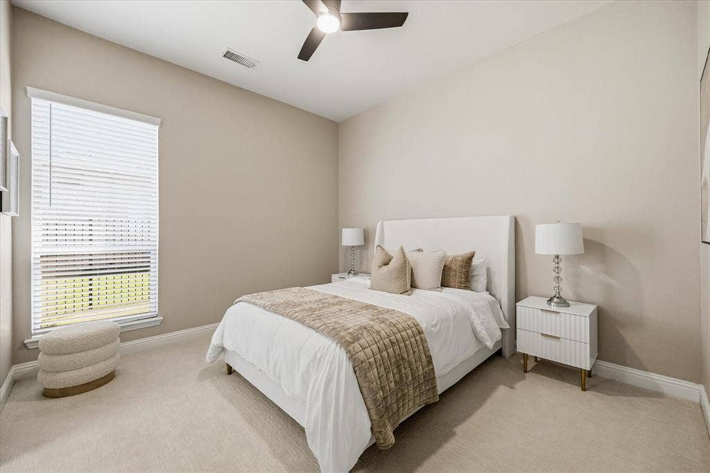 Carpeted flooring, vaulted ceiling, single window with blinds, and a ceiling fan with light fixture