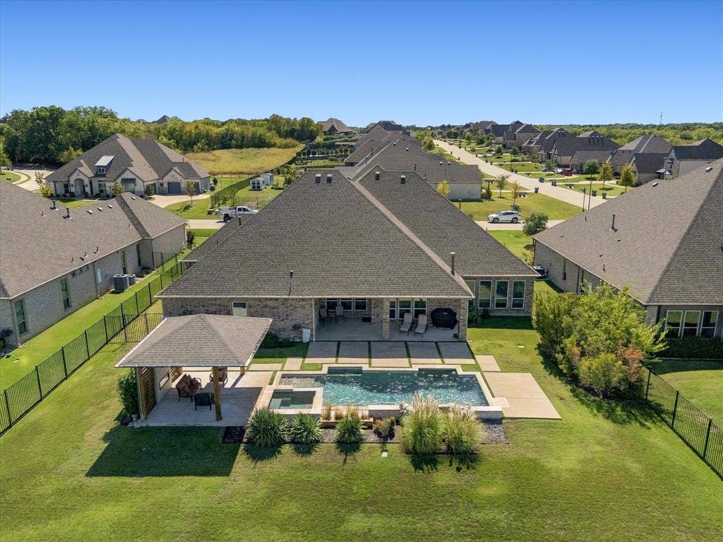 Expansive backyard featuring a swimming pool, integrated spa, and an covered patio