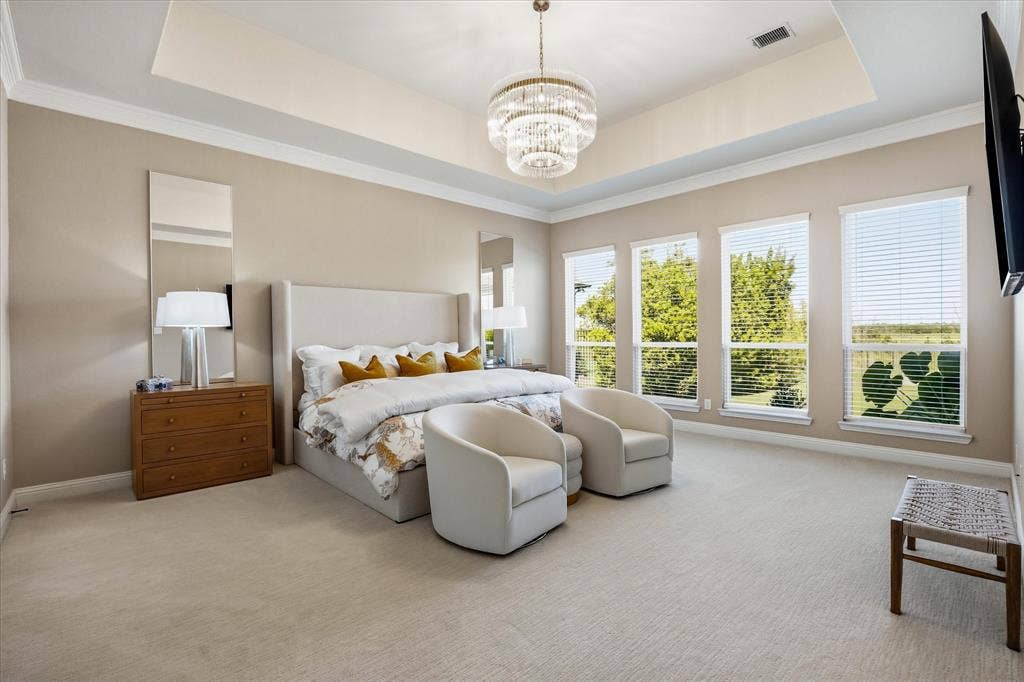 Expansive primary suite overlooking the serene pool and greenspace.