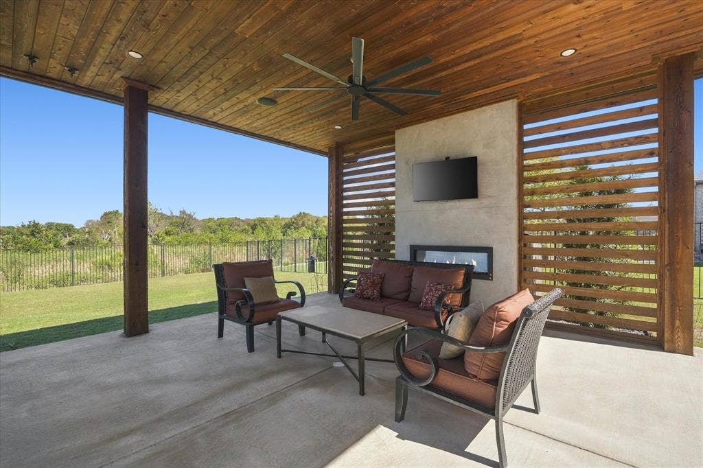Covered patio featuring a wood-plank ceiling, ceiling fan, recessed lighting, and a built-in fireplace