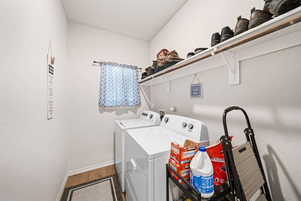 Built-in shelving with hanging rod, window with natural light, and wood-finish flooring