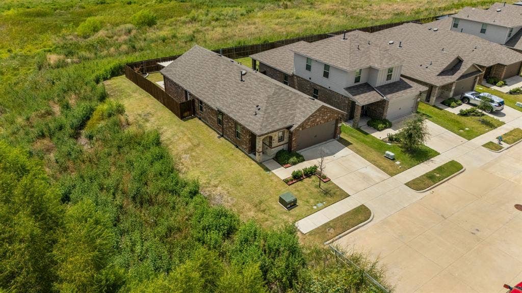 Single-story residence with brick and siding exterior, attached garage, and a fenced backyard