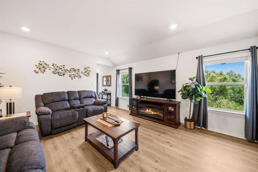 Recessed lighting, vaulted ceiling, wood-finish flooring, two large windows, built-in electric fireplace