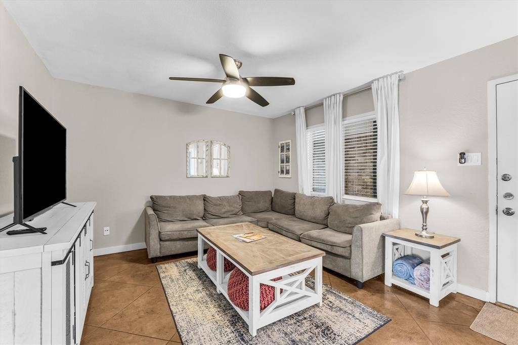 1214 Baylor Avenue, #109, Waco, TX 76706 Vaulted ceiling with a ceiling fan, multiple windows with blinds, and durable flooring throughout