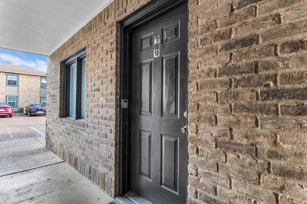 1214 Baylor Avenue, #109, Waco, TX 76706 Brick exterior facade with an integrated window, covered entryway, and panel door