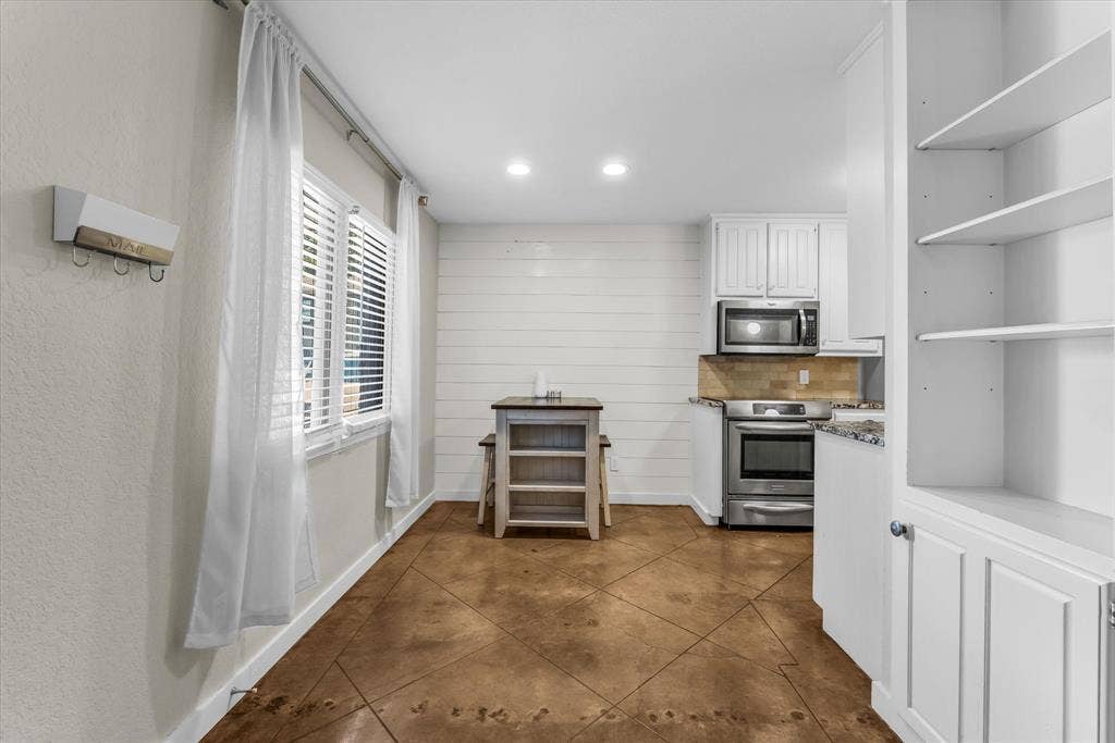 1214 Baylor Avenue, #109, Waco, TX 76706 Kitchenette featuring stainless steel appliances, white cabinetry, and a subway tile backsplash