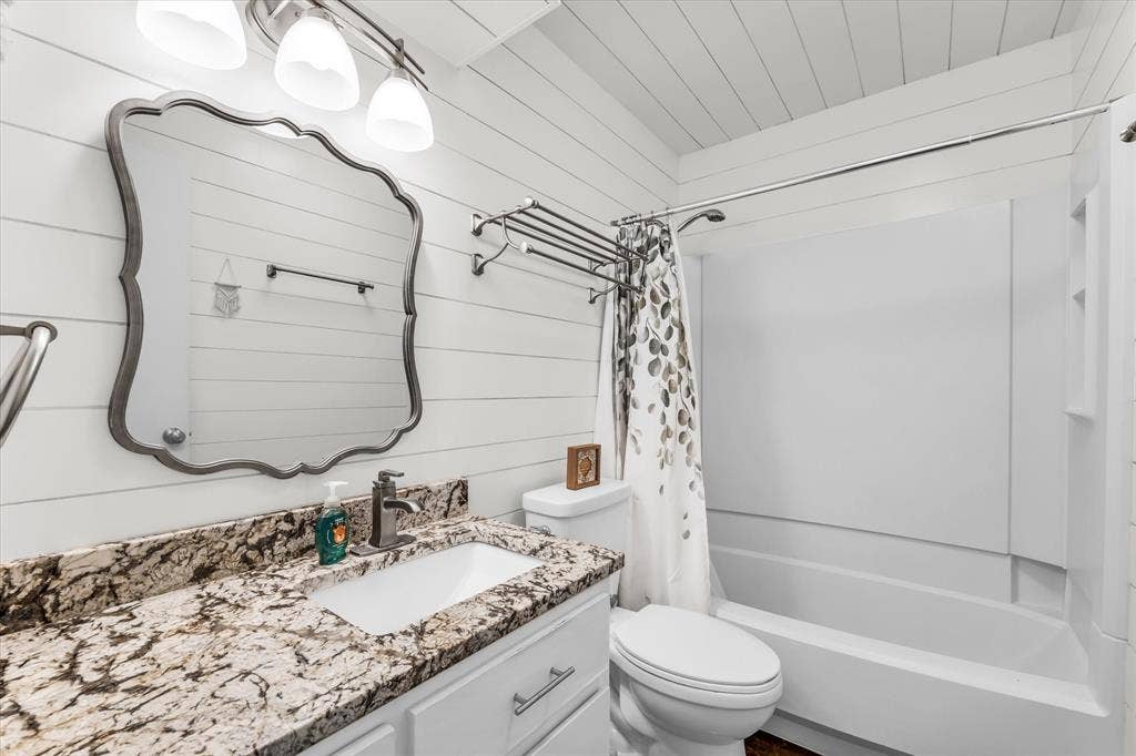 1214 Baylor Avenue, #109, Waco, TX 76706 Bathroom featuring a white vanity with a rectangular sink, speckled countertop, and a shower-tub combination