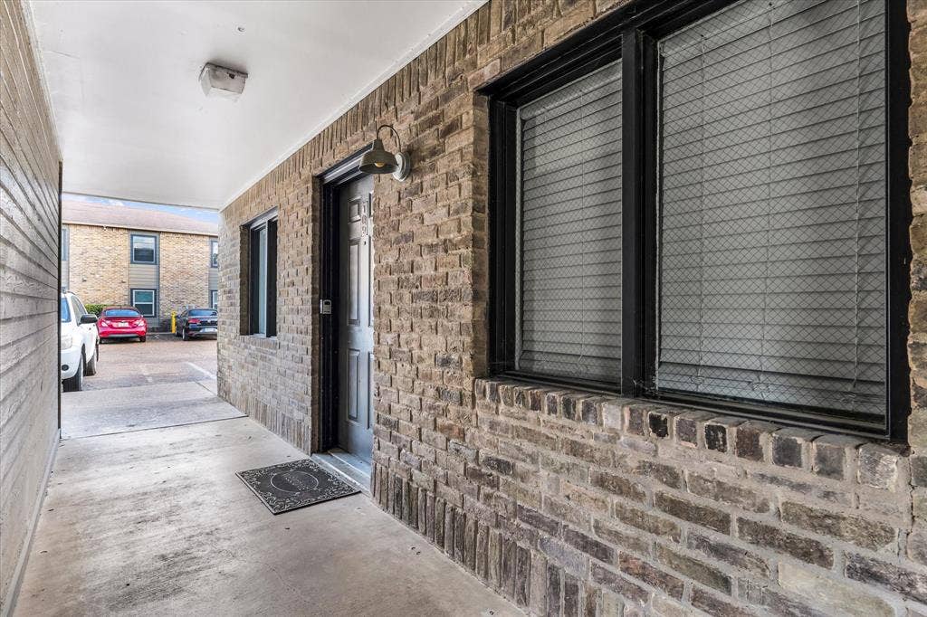 1214 Baylor Avenue, #109, Waco, TX 76706 Brick exterior with black window frames, an overhead light fixture, and a surface-mounted exterior light