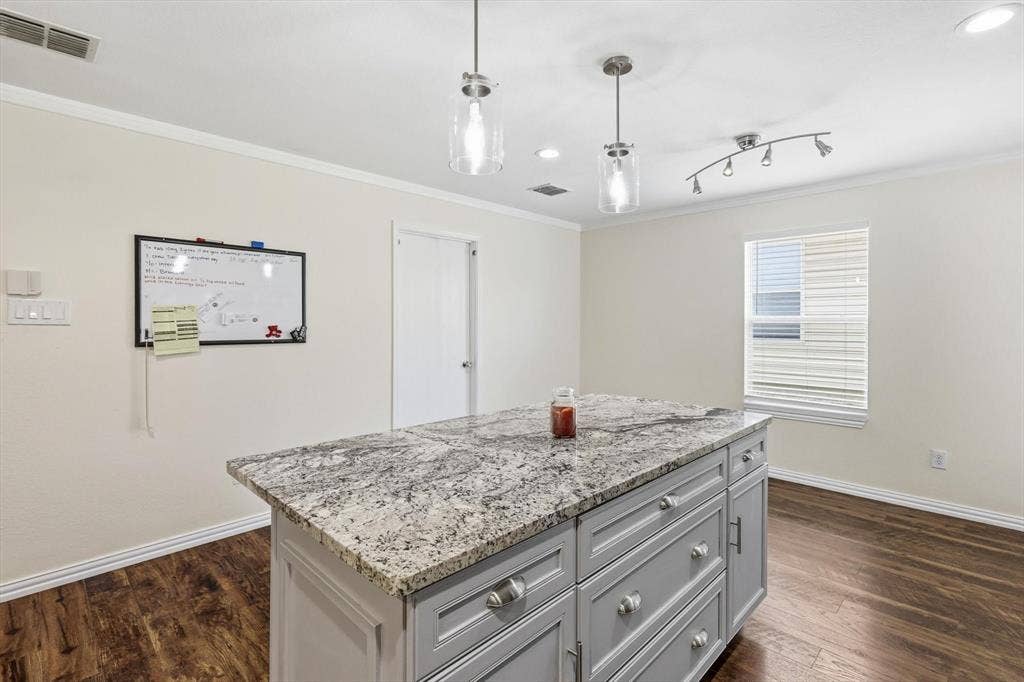 800 Poncho Lane, Fort Worth, TX 76052 Modern kitchen island featuring a granite-look countertop with waterfall edge, gray cabinetry with multiple drawers, and stainless steel hardware