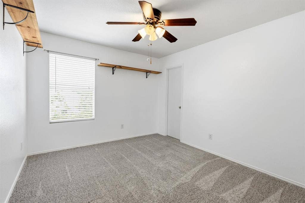 800 Poncho Lane, Fort Worth, TX 76052 Bright bedroom offering neutral carpet flooring, a ceiling fan with integrated lighting, large window with blinds for natural light control, and white walls throughout