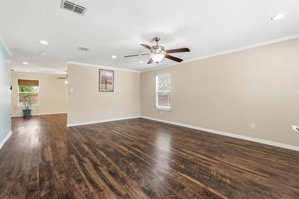 800 Poncho Lane, Fort Worth, TX 76052 Spacious open-concept living area showcasing rich wood-finish flooring throughout, neutral wall finishes, recessed ceiling lighting, and a ceiling fan with brushed nickel accents