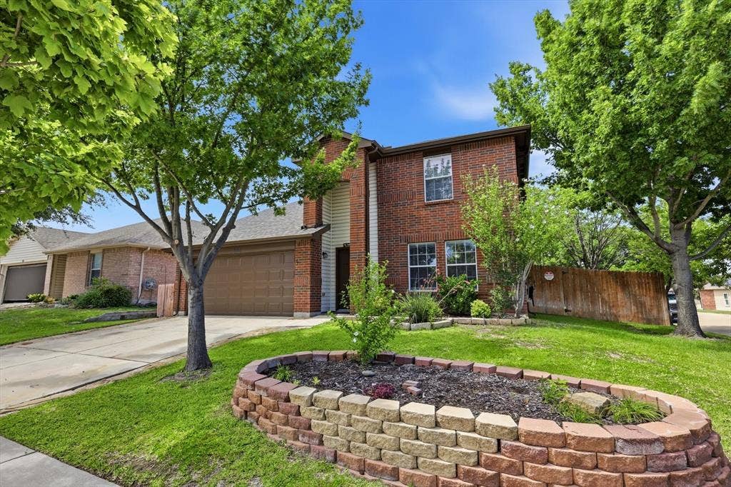 800 Poncho Lane, Fort Worth, TX 76052 Brick Colonial home featuring a manicured front lawn with mature shade trees and a curved brick planter bed