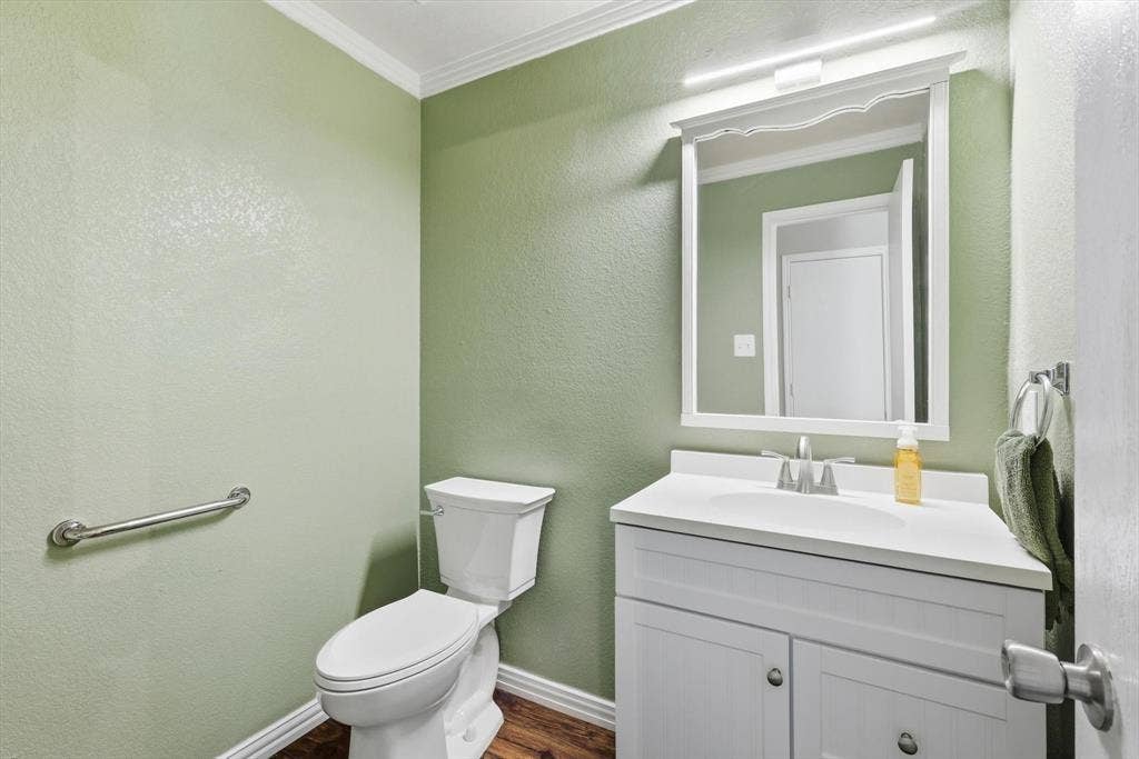 800 Poncho Lane, Fort Worth, TX 76052 White vanity with a single basin sink, wall-mounted mirror, and wood-finish flooring